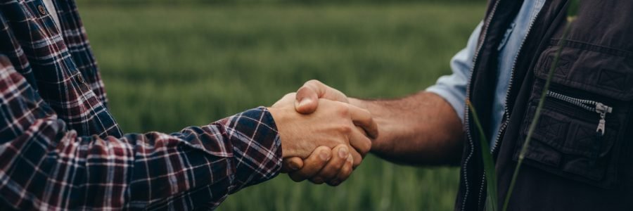 close up of two man handshake on field